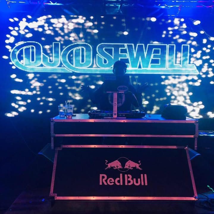 DJ D. Sewell behind a Red Bull DJ booth with his name in lights
